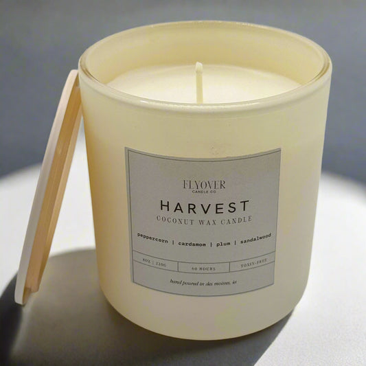 Candle in a white container with a label on a white background