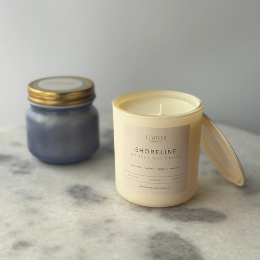 Two candles on a marble surface with a neutral background