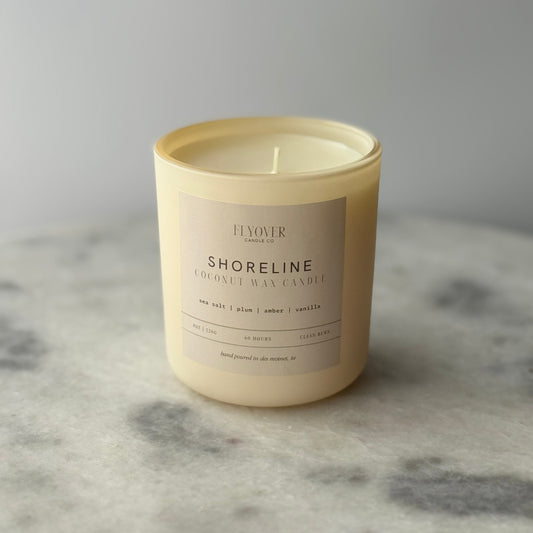 Beige candle with a label on a gray marble surface