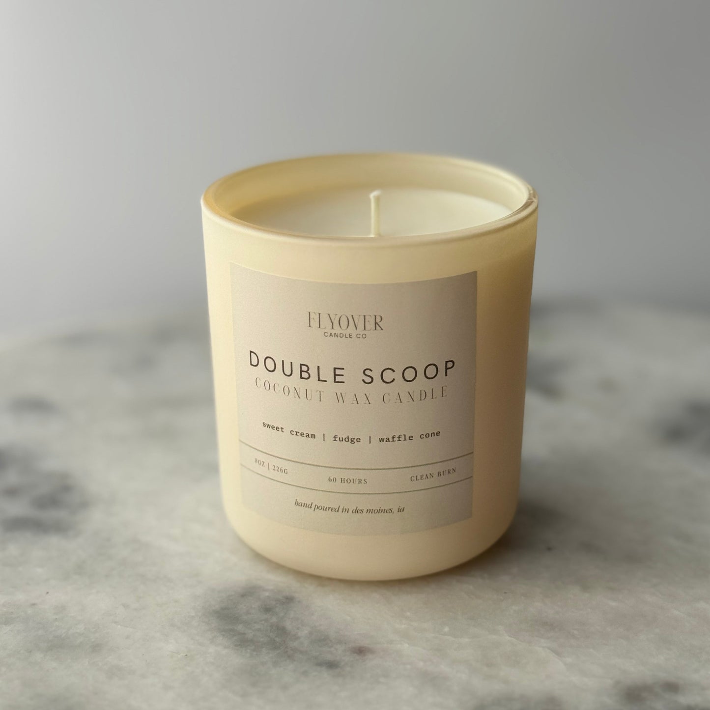 Candle with a label on a gray surface