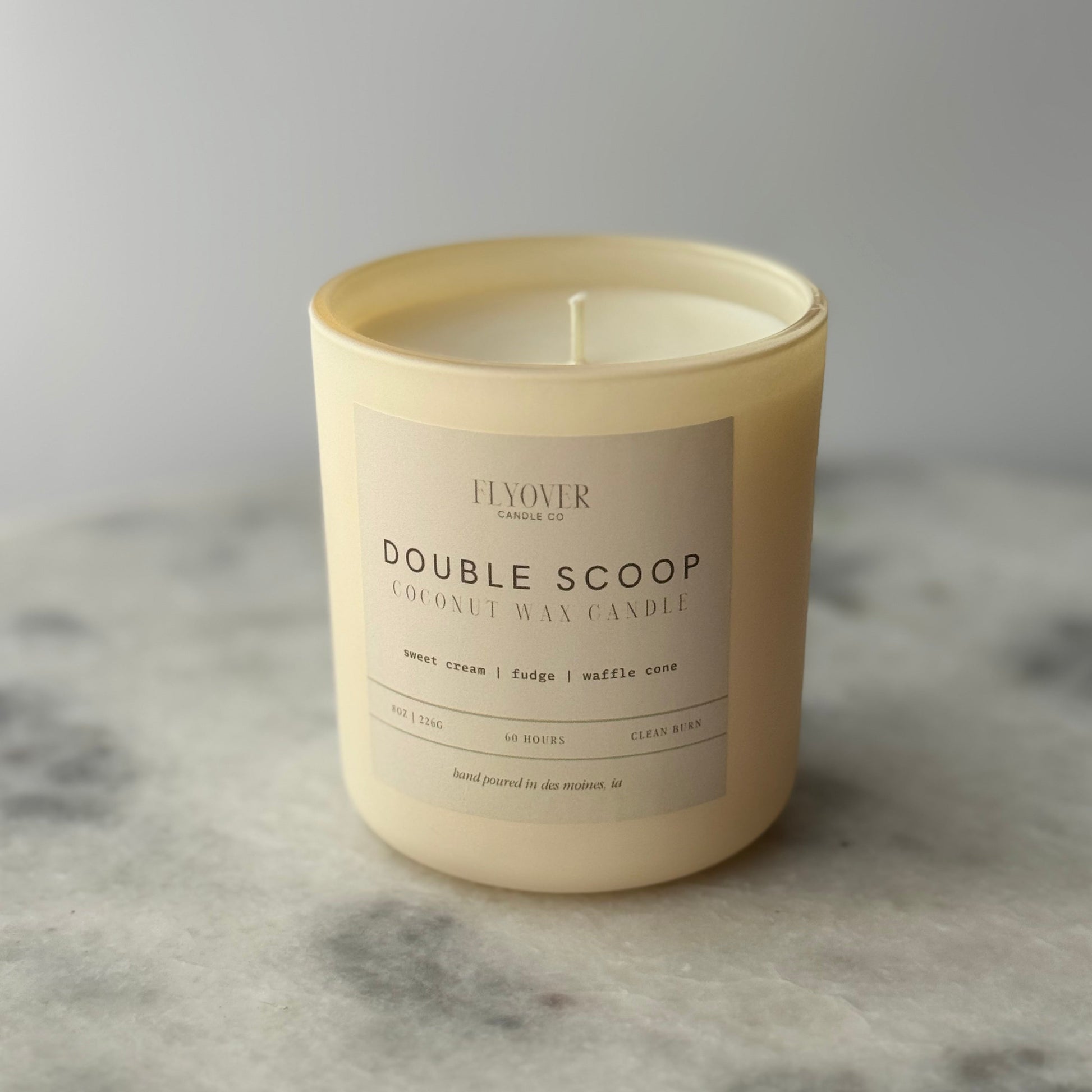 Candle with a label on a gray surface