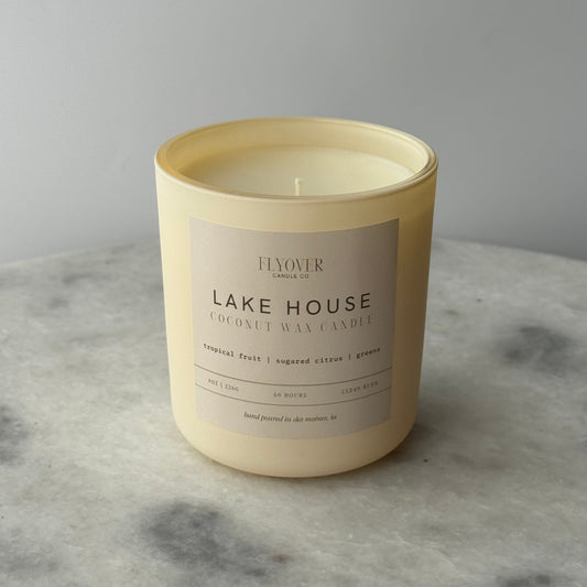 Candle with 'Lake House' label on a marble surface