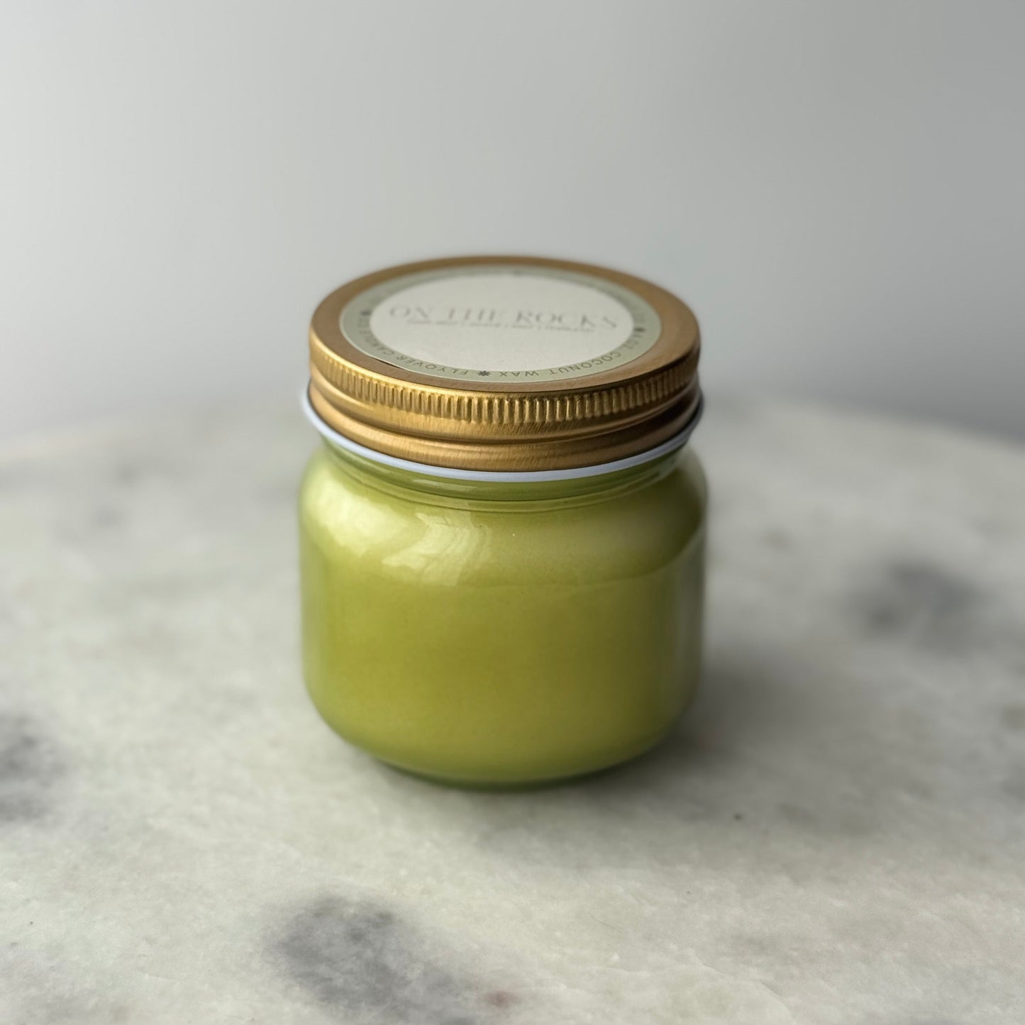 Small jar with a gold lid on a textured surface